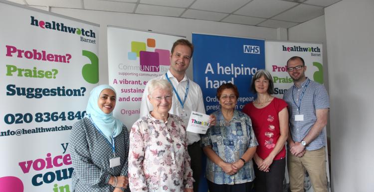 Three women and two men who are volunteers and staff standing